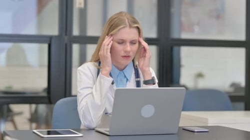 Doctor Experiencing Headache at Desk with Laptop