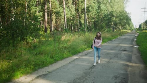 Student Walking Calmly Along Lonely Road Through Forest