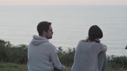 Couple Enjoying Ocean View at Sunset Together. Romantic Moment: Pair Overlooking Sea at Dusk