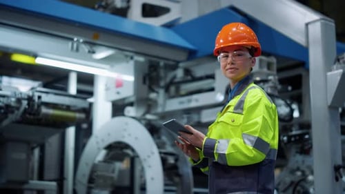 Focused Engineer Working Tablet on Modern Production Factory. Serious Industrial Engineer Holding