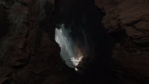 A Cave with a Stunning Ray of Light Shining Through a Large Hole in the Ceiling
