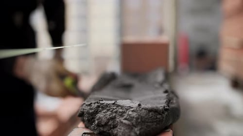 Worker Applying Mortar with Trowel During Bricklaying