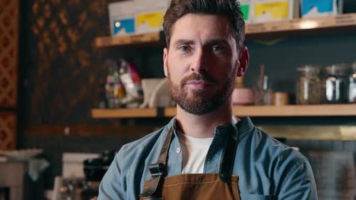 Smiling Barista Wearing Apron in a Coffee Shop