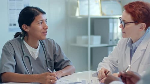 Team of Doctors Having Discussion during Meeting in Medical Office