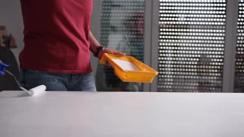 Woman Painting White Table with Roller Indoors