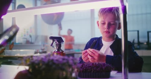 Child Carefully Separates Plants in Science Classroom