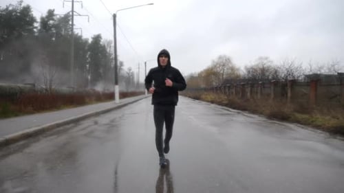 Strong Athlete in Sportswear Jogging Along Trail at Cloudy Day Young Sportsman Running Along Asphalt