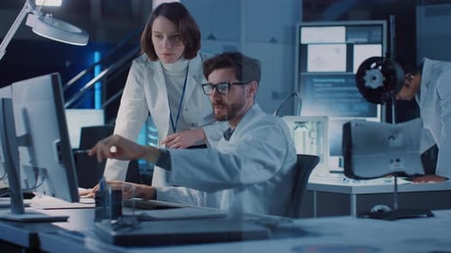 Scientists Collaborate, Reviewing Data on Computer Screen