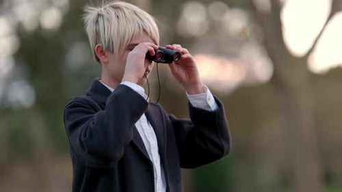 Teen with binoculars in a park setting