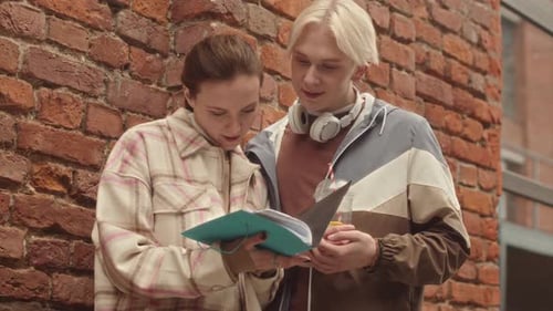 Caucasian Couple of Students Discussing Homework Outdoors