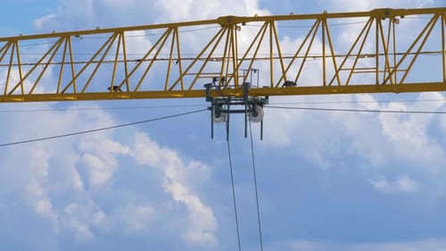 Big yellow crane moving a load along its jib