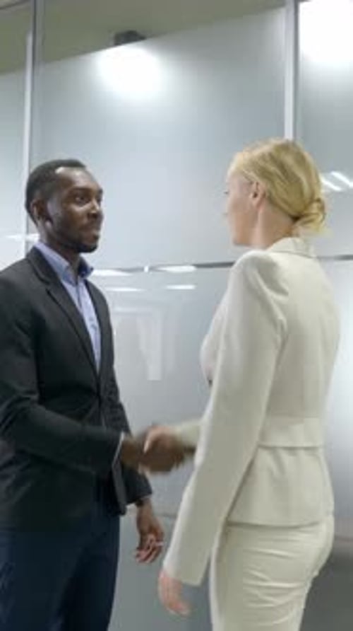 Business Professionals Shaking Hands in Modern Office Setting Showcasing Collaboration and