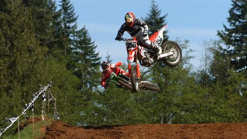 Motocross Riders Jump Over Dirt Hills in a Forest