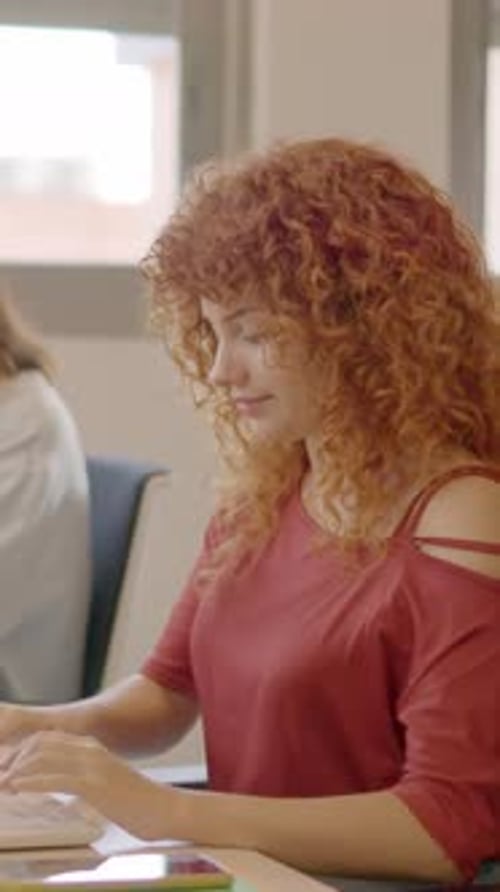 Femme aux cheveux bouclés travaillant concentrée au bureau