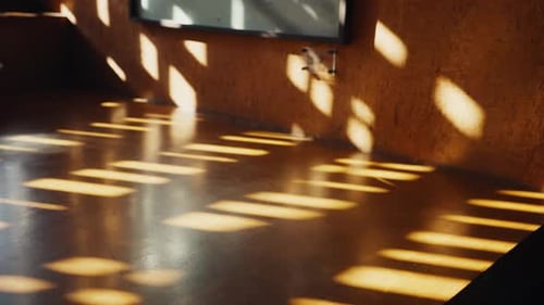 Goldenes Sonnenlicht bewegt sich über einen dunklen Raumboden
