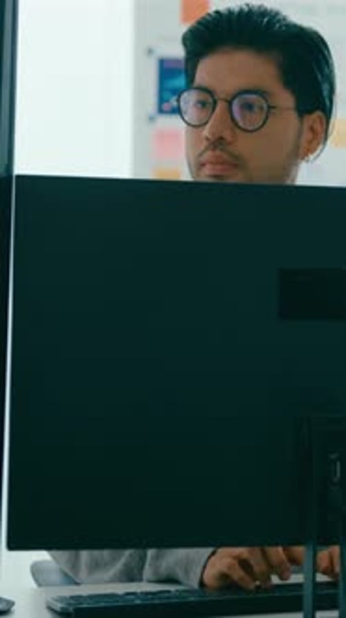 Focused Young Man Working at Computer in Office