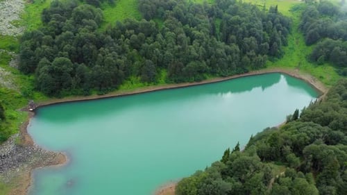 Panning camera over turquoise Green Lake surrounded by forest