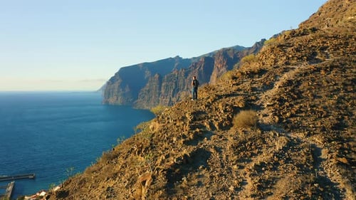 Man Backpacker Standing on Mountain Rock and Enjoying Epic Viewpoint Colorful Sunset and Endless