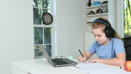 Girl Doing Homework With Laptop at Home