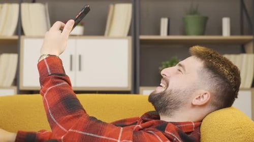 Young Adult Enjoys Video Call Lying on Couch