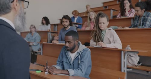 Male and Female Students Diverse Group Listening to Professor Studying in University Writing