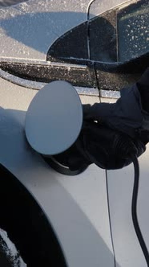 Gloved Hand Closes Charging Port on Electric Car