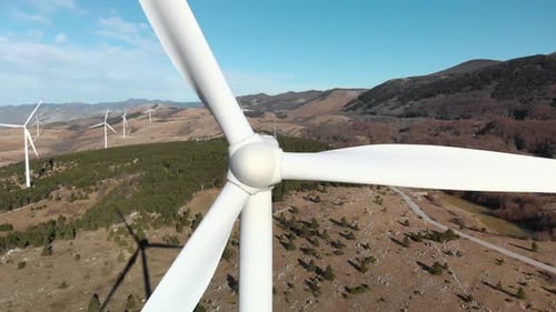 Drone close up wind mill tower that converts rotary energy into electricity sustainable green energy
