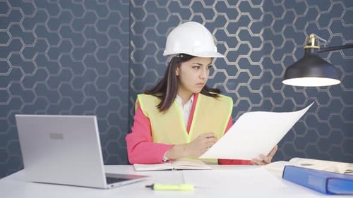 The woman engineer examines the project in her hands.