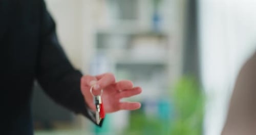 Mann übergibt dem Kunden die Schlüssel zur neuen Wohnung