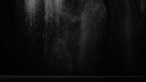 Sahara Collection: Sand sprinkling from the top and scattering over a black background shot at 60fps