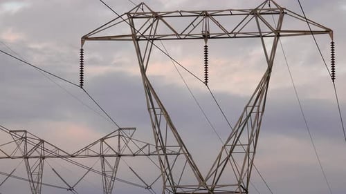Electrical towers against grey clouds.