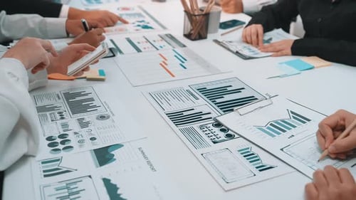 Team Analyzes Charts and Graphs at Office Meeting