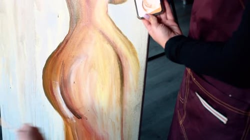 Beautiful woman painting with watercolors at an art gallery workshop