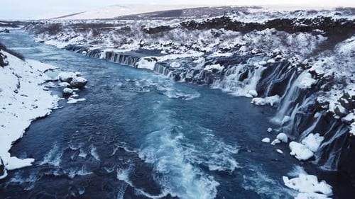 Waterfall in Iceland Frozen Snowy Mountain with Cold River in Winter Aerial