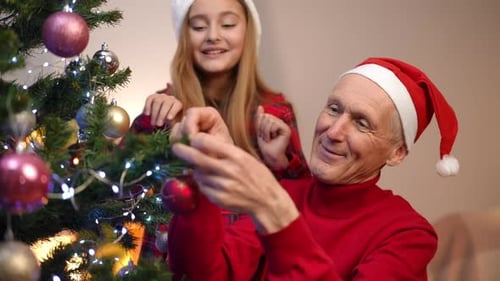 Grandfather and Granddaughter Decorating Christmas Tree Together