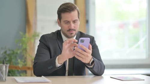 Businessman Using Smartphone at Work