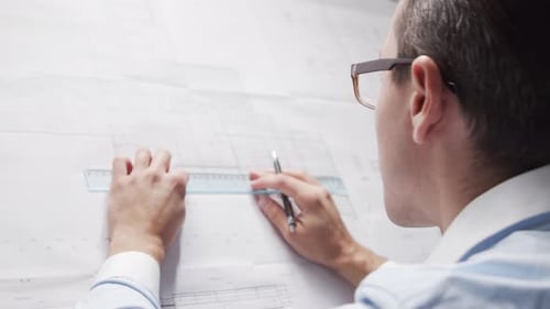 Architect Works in Loft Using Drawing Board Workplace of Young and Serious Engineer in Modern Office