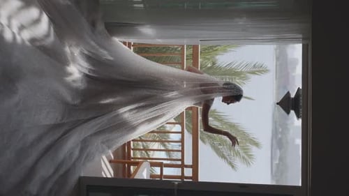 Woman in White Wedding Dress Posing on Balcony