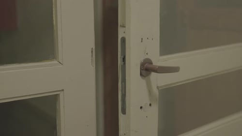 Close-up of a white vintage door with metal handle, indoor setting