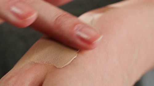 Junge Frau checkt bei der Auswahl von Handpflegecreme im Kosmetik-Supermarkt Ton- oder Lippenstiftkontrolle
