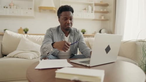 Man Working on Laptop at Home During Daytime
