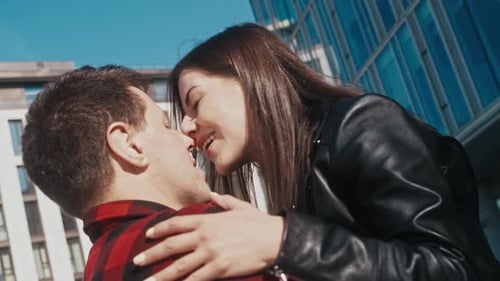 Man and Woman in Love Hug and Kiss Outside Modern Buildings in City