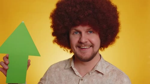 Smiling Man Holds Green Arrow Pointing Up