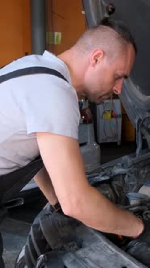 Mechanic Working on Car Engine in Garage Workshop Concept of Car Service and Car Maintenance