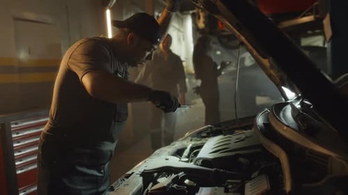 Mechanics Inspecting Car Engine in Repair Garage