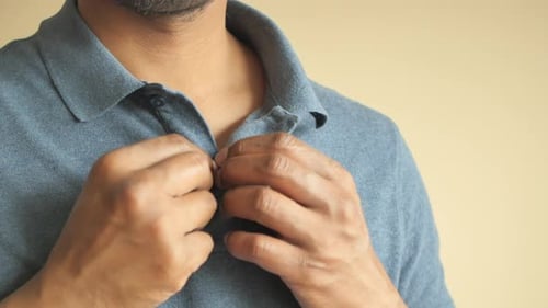 Man Buttoning His Shirt Close Up