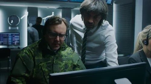 Men and woman working in dark operations center