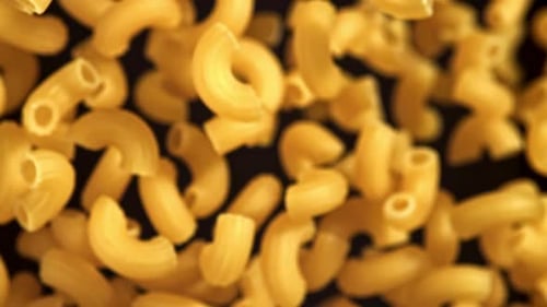 Dry Elbow Macaroni Pasta Falling in Slow Motion