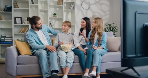Family of Four Watching TV on Couch
