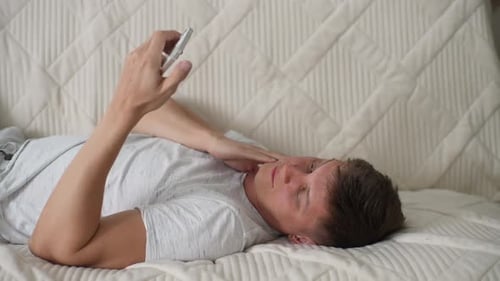 Young Adult Lying Down with Mobile Phone